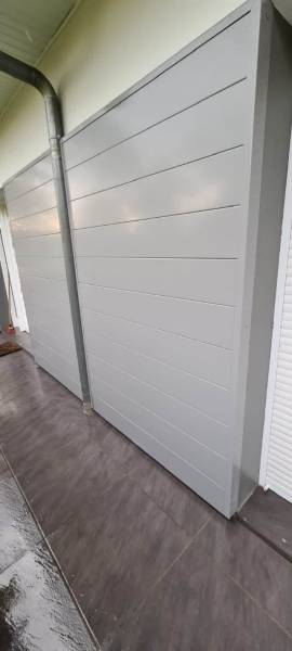 Création d'un bardage plan en aluminium pour protéger la façade d'une maison à Saint-Pierre-Du-Mont