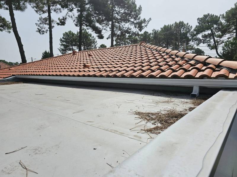 Installation par DAL'ALU de gouttières blanches avec descentes et parafeuilles sur une maison à Mimizan