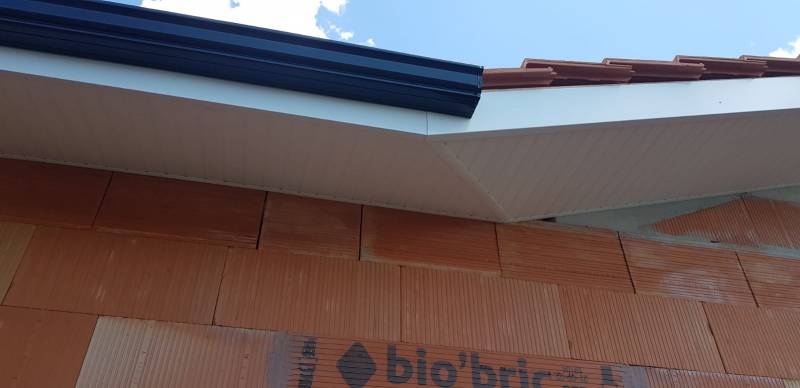 Lambris PVC blanc, habillage aluminium et gouttières noires à Biscarrosse