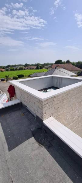 Alu Plus Gouttières réalise la pose de couvertine en aluminium sur un mur d'une maison située à Laroin