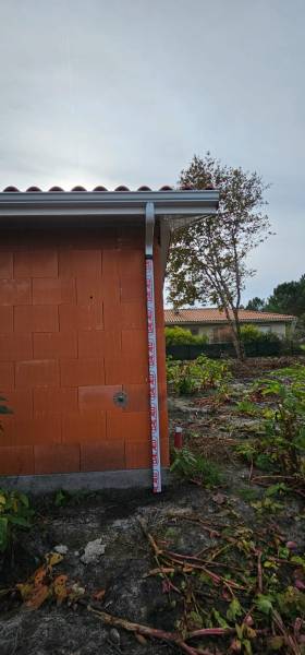 Installation de gouttières G300 blanches avec descentes 60x80 pas chers pour la façade d’une maison située à Biscarrosse