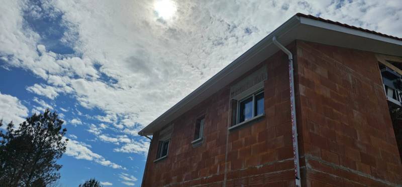 Gouttières corniche traditionnelle G300 avec descentes 60x80, sous-faces PVC et bandeaux en aluminium couleur blanche à Luë