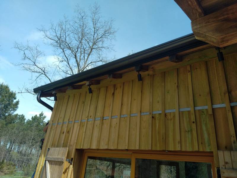 Comment installer des gouttières et leurs descentes noires graphite à Moustey ?