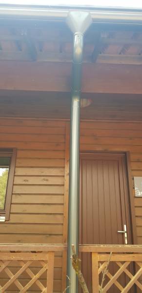 Installer de gouttières demi-rondes et de leurs descentes bleu ardoise sur un chalet situé aux alentours d’Or