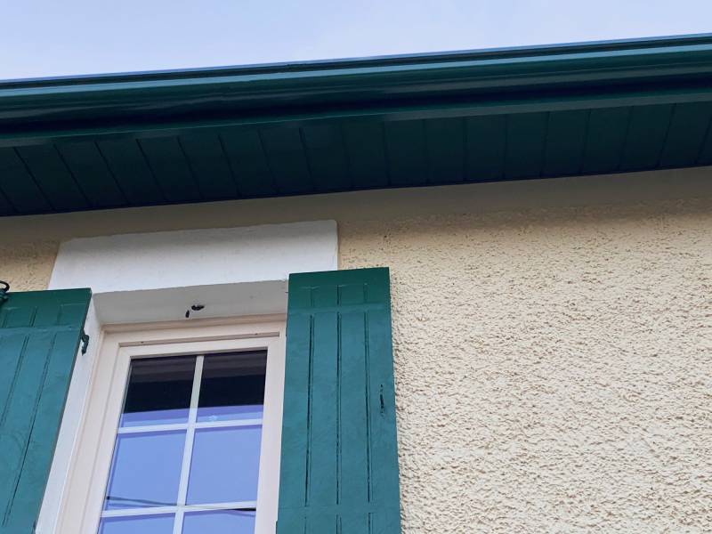 En accord avec les volets, l'habillage vert sapin vient sublimer la façade