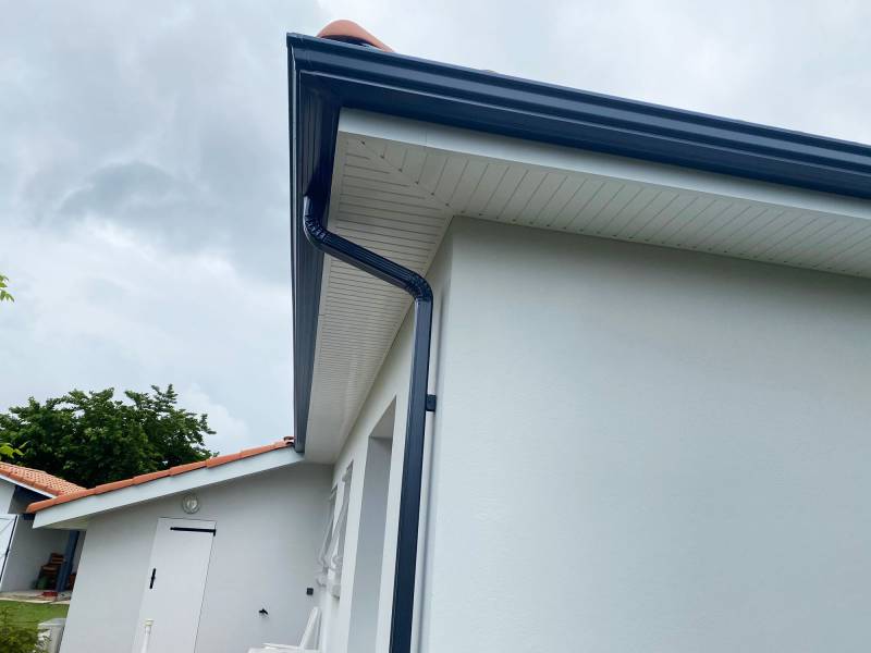 Pose de gouttières gris anthracite pour la rénovation de la façade de cette maison à Mimizan