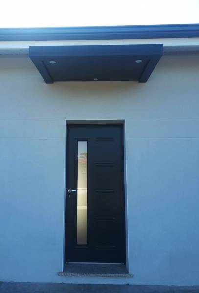 Réalisation de marquises en aluminium et pose au-dessus de portes d'entrée 'une résidence neuve dans le nord des Landes