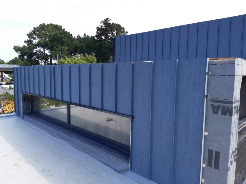 Réalisée par l'entreprise Alu Gouttières Bisca, la pose de la façade en joint-debout s'associe parfaitement au boisl