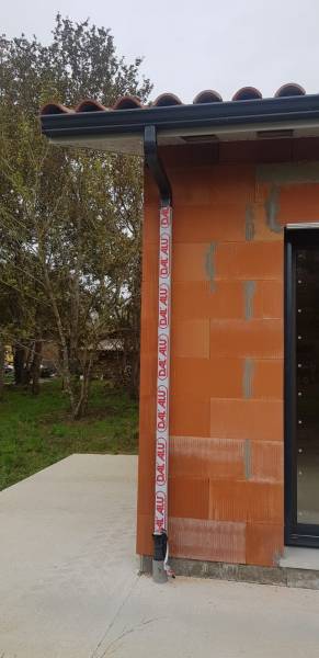 Pose par Alu Gouttières Bisca d'un habillage de bandeaux aluminium blanc, de gouttières G300 et de descentes 60x80 blanches à Mimizan