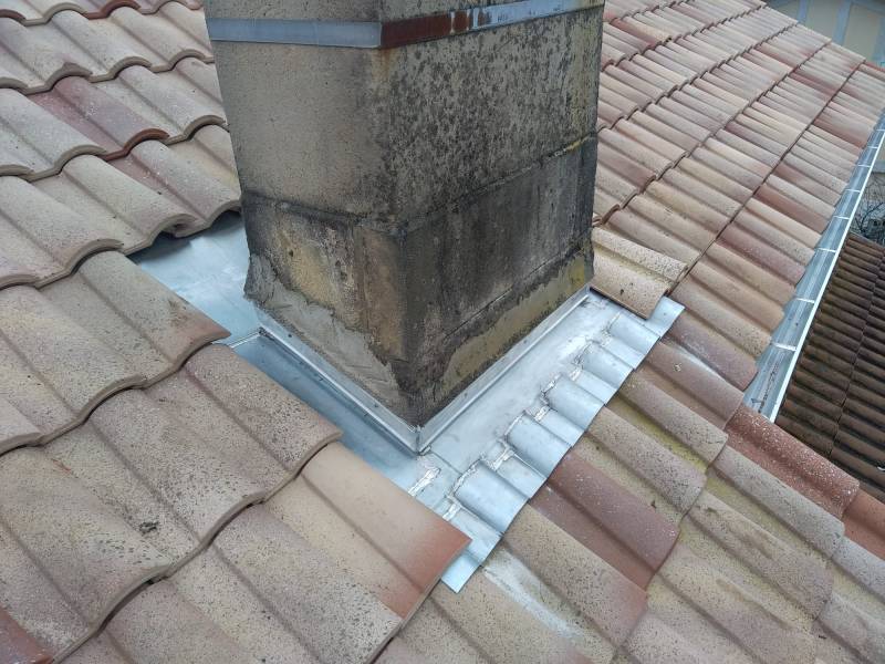 Comment un entourage de cheminée en zinc discret et durable valorise une toiture à Pissos dans les Landes