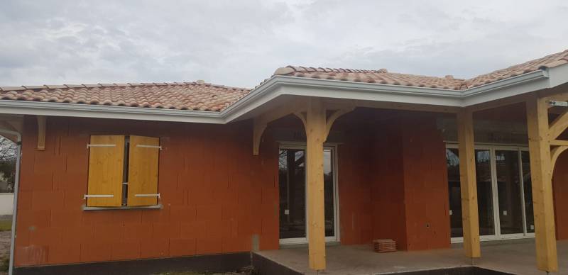 Gouttière et descente blanche sur une résidence en construction près d’Orx