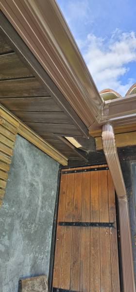 Sous-face en aluminium de couleur chêne foncé, gouttières G400 et leurs descentes marrons à Belin-Béliet dans les Landes