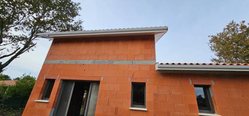 Installation de gouttières G300 blanches avec descentes 60x80 sur mesure pour la façade d’une maison située à Biscarrosse