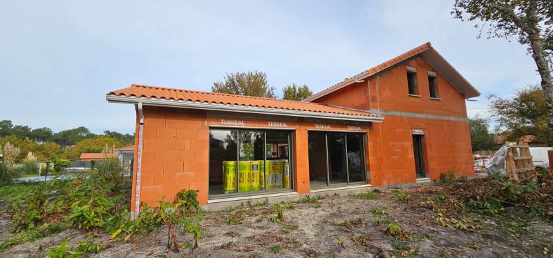 Installation de gouttières G300 blanches avec descentes 60x80 pour la façade d’une maison située à Biscarrosse dans les Landes