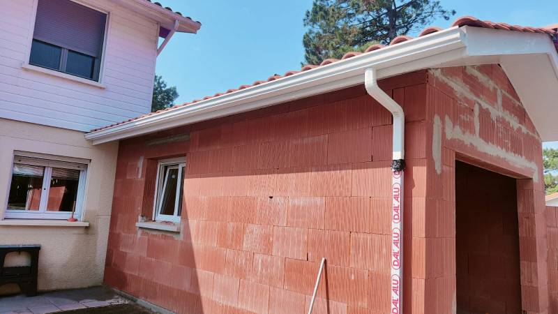 Mise en place de gouttières et de descentes en aluminium blanc sur une maison située à Biscarrosse